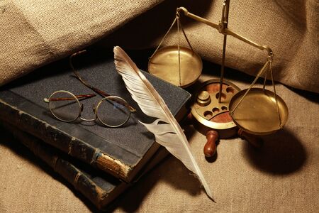 Vintage still life with old books and quill pen on canvas backgroundの写真素材