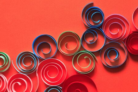 Multicolored spirals made from paper on red backgroundの写真素材