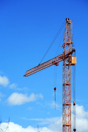 Industrial theme. Yellow construction crane against blue skyの写真素材