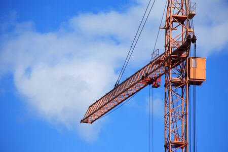Industrial theme. Yellow construction crane against blue skyの写真素材