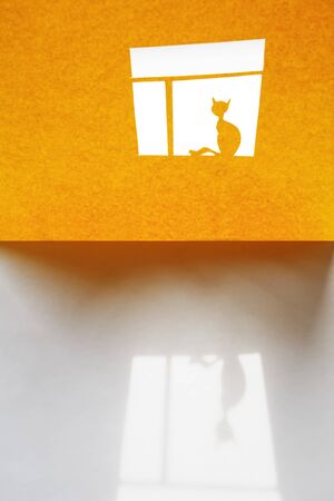 Composition cutting from yellow paper. Alone cat on the  windowの写真素材