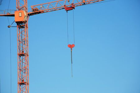 Industrial theme. Yellow construction crane against blue skyの写真素材