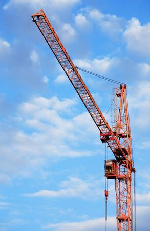 Industrial theme. Yellow construction crane against blue skyの写真素材