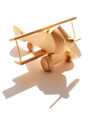 Travel concept. Small wooden airplane against sunlight with shadowの写真素材