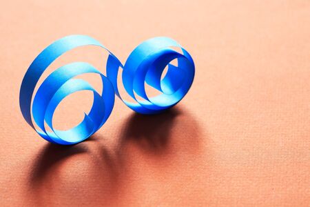 Two blue spirals made from paper on red backgroundの写真素材