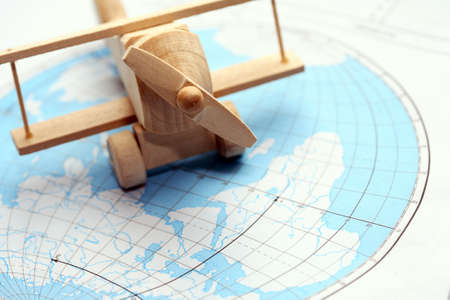 Travel concept. Small wooden airplane on map of worldの写真素材