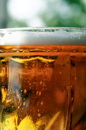 Mug of beer with foam closeup as backgroundの写真素材