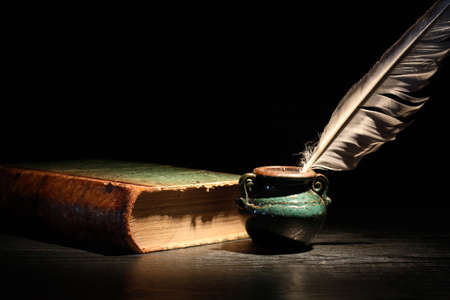 Vintage still life with old book and quill pen on dark backgroundの写真素材