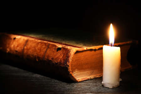 Vintage still life with lighting candle near old bookの写真素材