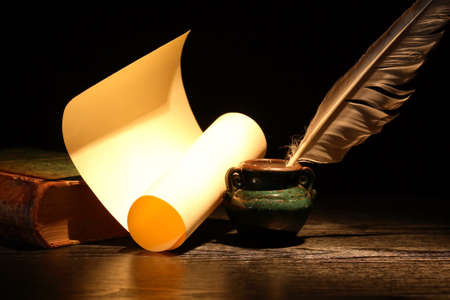 Vintage still life with old book and quill pen on dark backgroundの写真素材