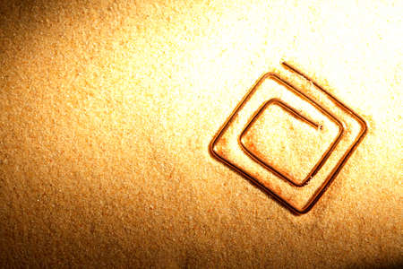 Abstract symbol made from copper wire on sand surfaceの写真素材