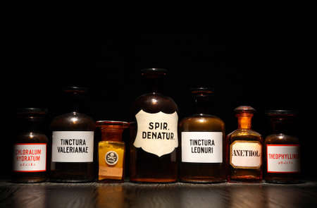 Few old bottles with medicines in a row on dark backgroundの写真素材