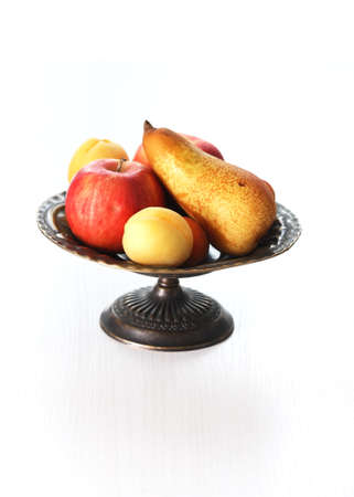 Heap of freshness fruits in vintage bowl on white tableの写真素材