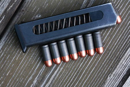 Handgun cartridges closeup on old wooden backgroundの写真素材