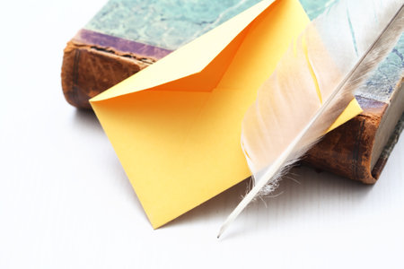 Still life with book and quill pen near empty envelopeの写真素材