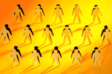 Lot of men figures cutting from yellow paper with long shadowの写真素材