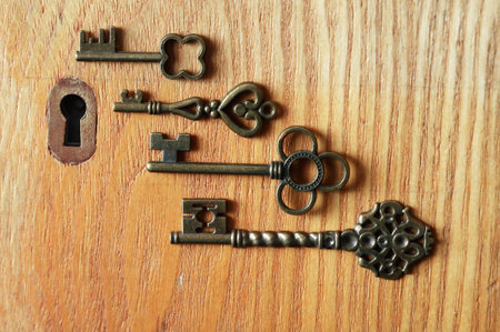 Set of various old keys closeup near keyholeの写真素材