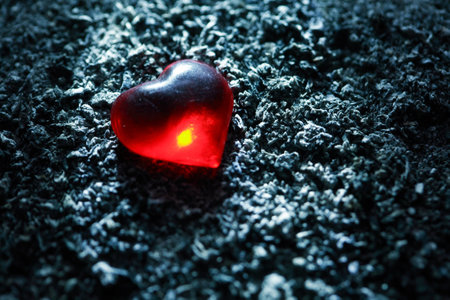 love concept. Red glass heart on gray ash backgroundの写真素材