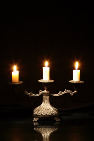 Nice vintage candlestick with lighting candles on dark backgroundの写真素材