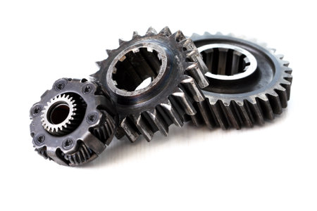 Part of the mechanism. Few old black gears on white backgroundの写真素材