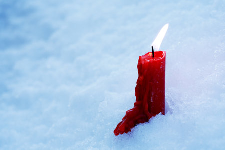 A symbol of memory. A single candle burns in the snowの写真素材
