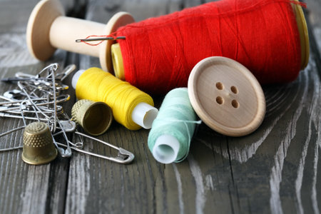 A set of multicolored threads and sewing tools on old wooden board