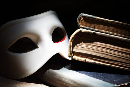 Nice white Venetian mask near books on dark backgroundの写真素材