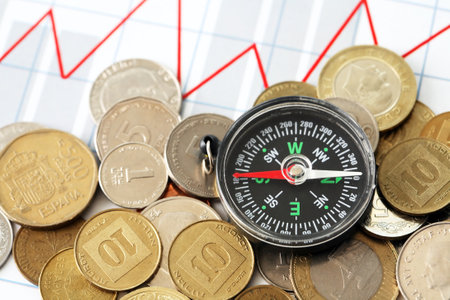 Business concept. Set of coins columns in a row and compass on diagram backgroundの写真素材