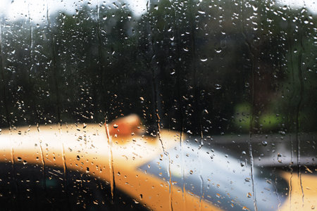 City life in the summer rain through a glass with dropletsの写真素材