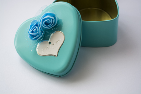 Metal box in the form of heart with the inscription "I Love You" and with roses. Blue color. White background.の写真素材