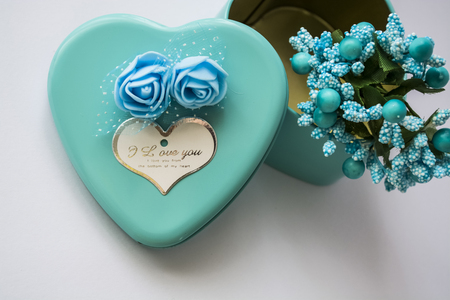 Metal box in the form of heart with the inscription "I Love You" and with roses. Blue color. Turquoise. St. Valentine's Day. White background. Flowers inside.の写真素材