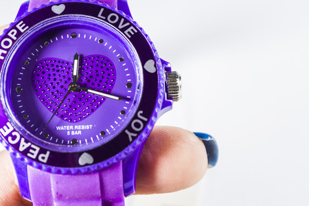 White monophonic background. The violet electronic clock on a hand. Love. A blank space for an inscription.の写真素材