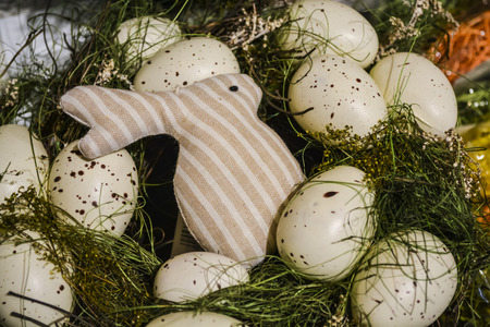 Easter rabbits and eggs. A decor for a holiday. Wreaths and flowers. Bright jewelry.