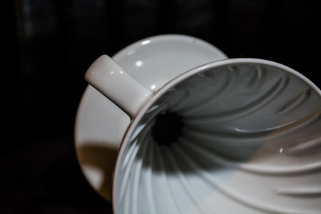 White funnel Pourover on a black background for preparation of coffee by an alternative method. Work...