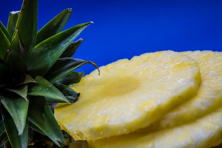 Slices of the fresh and cut pineapple on monophonic and bright background. Tropical, citrus fruit. A natural product for health. Exotic.の写真素材