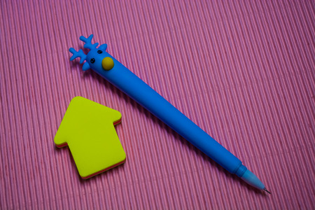 On monophonic bright pink background the unusual blue pen with the head of deer. Nearby lie...