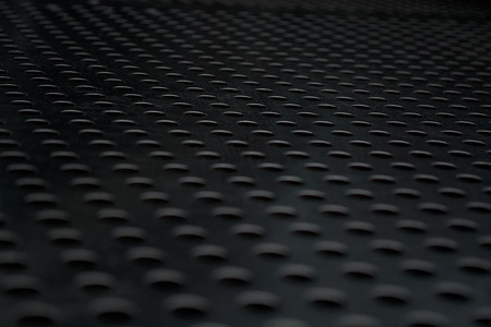 Gray monophonic background with big quantity of holes in a metal plate. Surface. Textureの写真素材