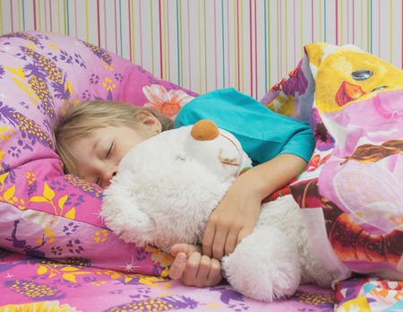 Beautiful little girl with a toy polar bear. The concept of a happy childhood.の写真素材