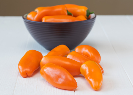 Orange bell pepper in a bowl on a wooden table. Healthy food concept.の写真素材