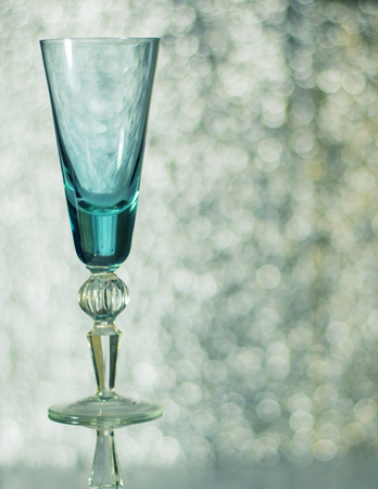Tall glass wine glass on the background bokeh. Shallow depth of field. Christmas card.の写真素材
