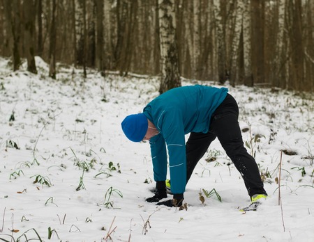 man performs exercise in the winter woods. Healthy lifestyle concept.の写真素材