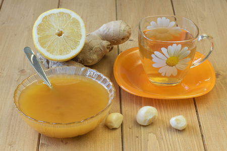 The root of ginger and honey on wooden table. The concept of treatment with natural products.の写真素材