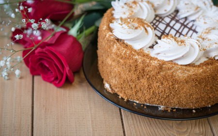 Honey cake with flowers and tea on a wooden table. Festive table decoration.の写真素材
