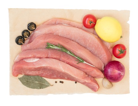 Sliced pork with vegetables and spices on paper. Isolated on white background. View from above.の写真素材