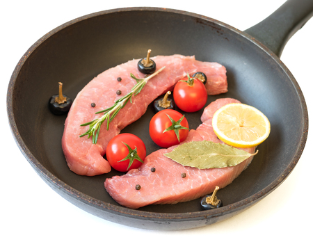 Raw pork on a frying pan isolated on white background. Ingredients for the preparation of meat dishes. Home kitchen.の写真素材