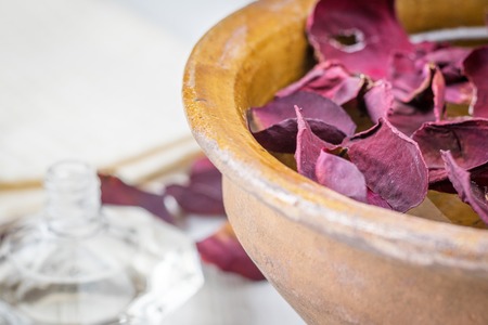 Spa background with beautiful rose petals and a clay bowl. Set for the treatment of skin and nails. Alternative medicine.の写真素材