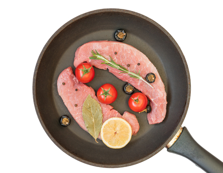 Raw pork on a frying pan isolated on white background. Ingredients for the preparation of meat dishes. Home kitchen.の写真素材