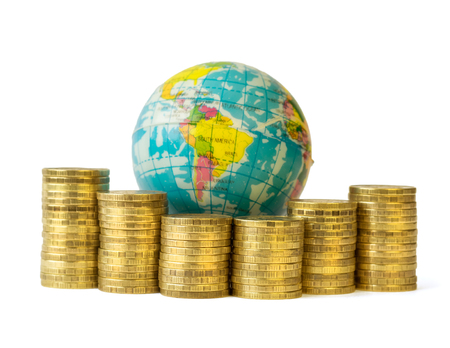 Metal coins and globe isolated on white background. The concept of budget travel. Money rules the world.の写真素材