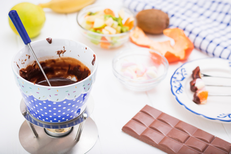 Fondue chocolate, marshmallows, apple, tangerine, kiwi and banana. Homemade holiday dish. Children's party.の写真素材