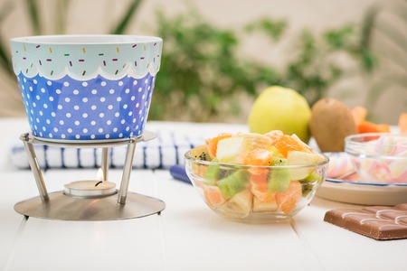 Fondue chocolate, marshmallows, apple, tangerine, kiwi and banana. Homemade holiday dish. Children's party.の写真素材
